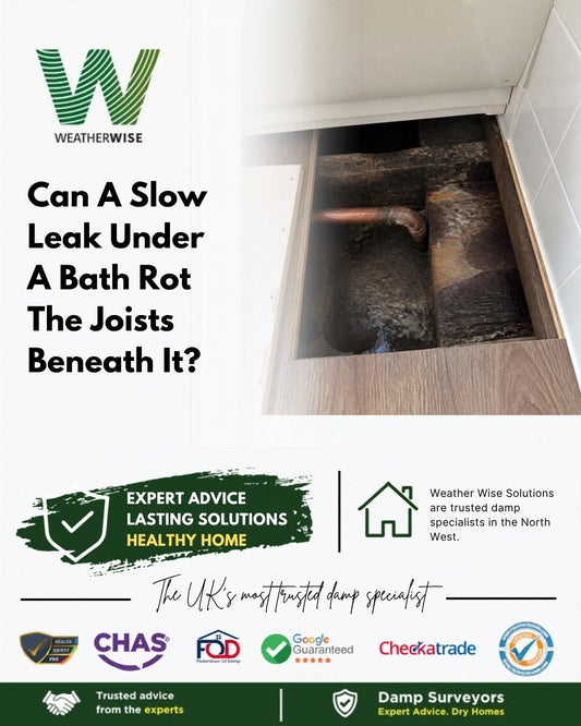 Can a slow leak under a bath or shower rot the floor joists beneath it? A removed bath access panel showing dark, damp-stained timbers and a copper pipe under a bathroom floor.